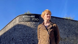 Uncaged podcast cover with Emily Knight at zoo entrance